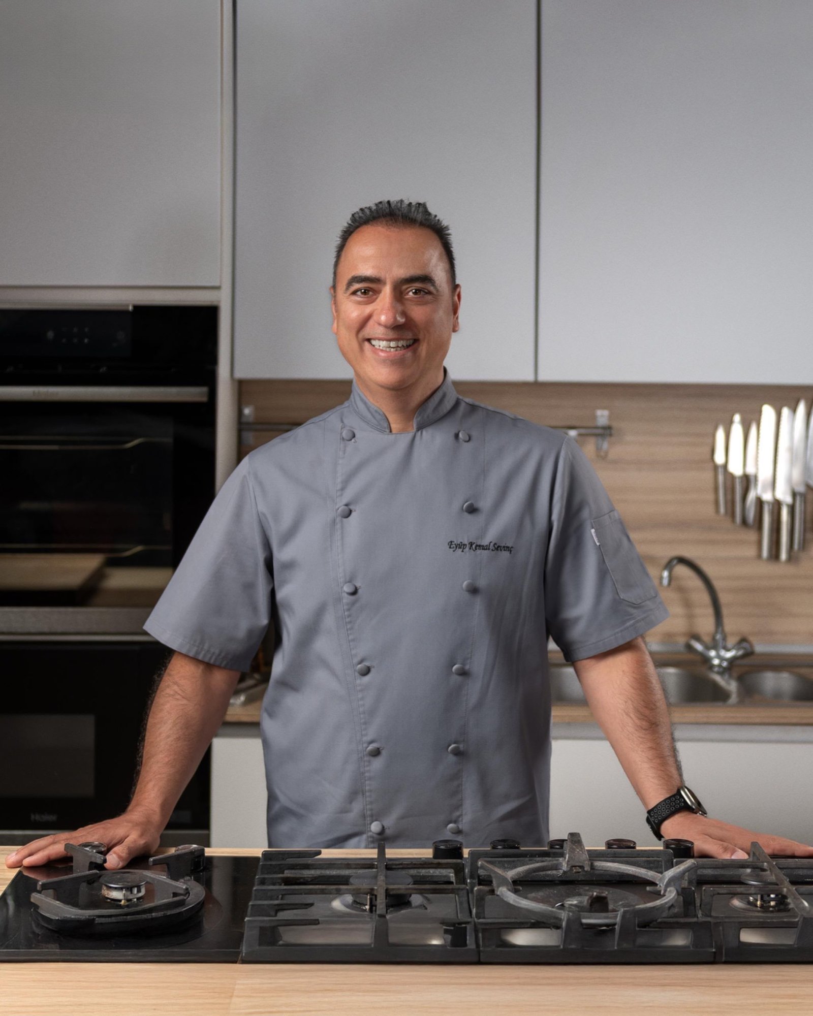Eyüp Kemal Sevinç in the kitchen, wearing a grey chef’s jacket